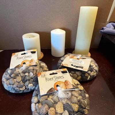 Three bags of decorative River Stones and candles.