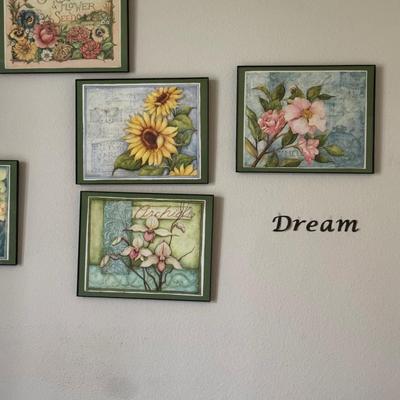 Wall art arrangement featuring framed floral prints and inspirational word decals, creating a cohesive and uplifting aesthetic.
