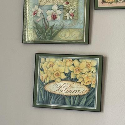 Wall art arrangement featuring framed floral prints and inspirational word decals, creating a cohesive and uplifting aesthetic.