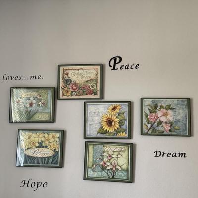 Wall art arrangement featuring framed floral prints and inspirational word decals, creating a cohesive and uplifting aesthetic.