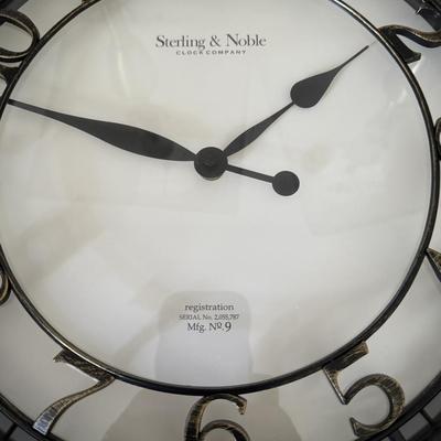 Pair of classic-style table lamps with cream-colored bell lamp shades and a large round wall clock with a dark frame and white face.