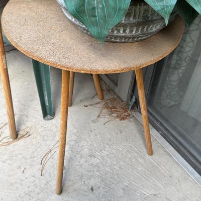 Two round accent or side tables, each holding a large potted plant, identified as a Artificial Philodendron.