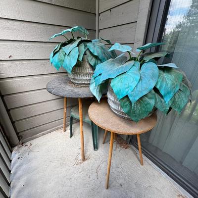 Two round accent or side tables, each holding a large potted plant, identified as a Artificial Philodendron.