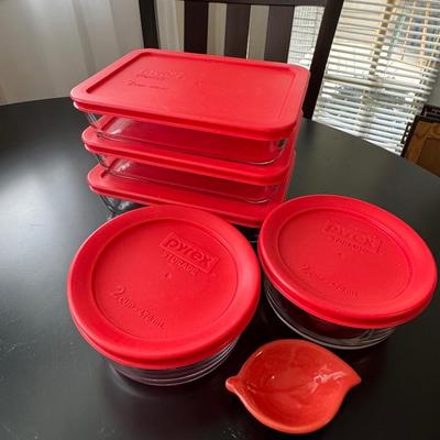 Pyrex glass storage containers with red lids.