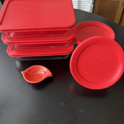 Pyrex glass storage containers with red lids.