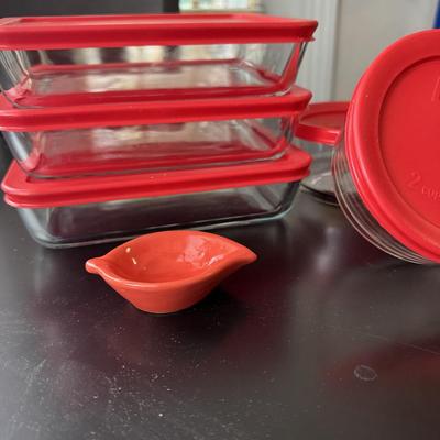 Pyrex glass storage containers with red lids.