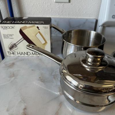 Stainless steel saucepan and a vintage hand mixer in its original box.