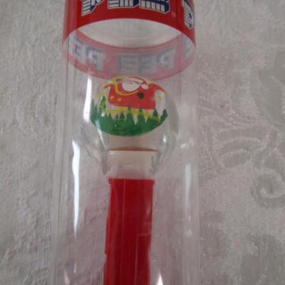 Sale Photo Thumbnail #422: String backpack, mug, Santa earrings, gift labels, new small string of lights (take 2 AA batteries not included), large Pez container, round Christmas tin, 2 ornaments