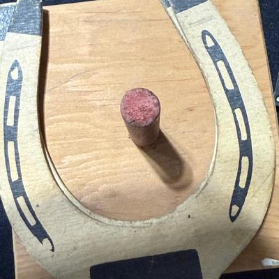 Dominos with wooden pegs, and cardboard horse shoes.