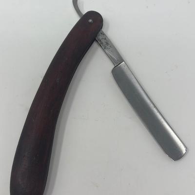 Sale Photo Thumbnail #418: In excellent condition, this vintage WWII NSDAP straight razor features a wood handle with a metal eagle and swastika emblem attached.