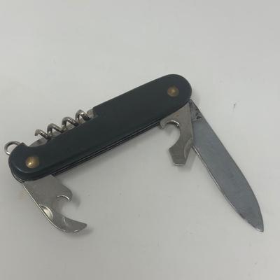 Sale Photo Thumbnail #426: Well used WWII German multi tool with an eagle and swastika emblem attached.