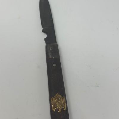 Sale Photo Thumbnail #431: Puma Solingen German WWII pocket knife. It has a wood handle and an eagle with swastika emblem attached. Very good condition.