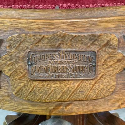 Sale Photo Thumbnail #455: "Congress Hydraulic Patented Koken Barbors Supply Co. St. Louis, USA"Adjustable headrest. Has golden finish, nickel plated trim and leather blade sharpener with quarter sewn oak Measures: 46" high x 22.5" wide (adjustable height)