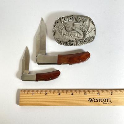 LOT 159: Kershaw 70th Anniversary Knives Serial No. E 1504 and E 9929, Sheaths and Pewter Pete Kershaw Numbered Belt Buckle
