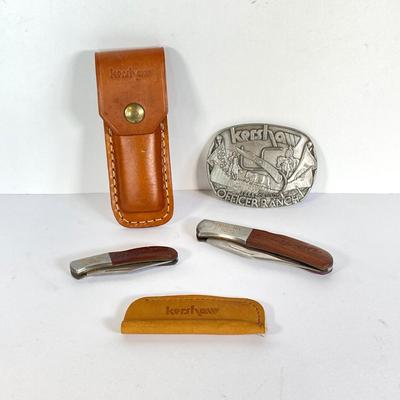 LOT 159: Kershaw 70th Anniversary Knives Serial No. E 1504 and E 9929, Sheaths and Pewter Pete Kershaw Numbered Belt Buckle