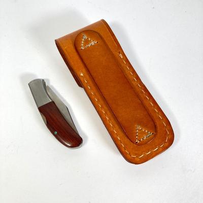 LOT 159: Kershaw 70th Anniversary Knives Serial No. E 1504 and E 9929, Sheaths and Pewter Pete Kershaw Numbered Belt Buckle