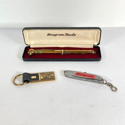 LOT 199: Snap-on Tools "The Master's Choice" Brass Tire Gauge, 70th Anniversary Key Chain and Miniature Utility Knife
