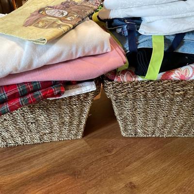 2 baskets full of tablecloths, placemats, and towels