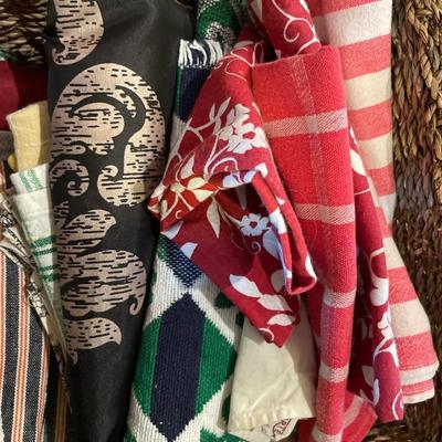 2 baskets full of tablecloths, placemats, and towels