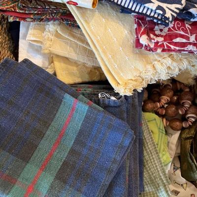 2 baskets full of tablecloths, placemats, and towels