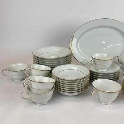 Sale Photo Thumbnail #944: This lot includes a tea pot, a creamer, sugar, 7 teacups, 7 saucers, 7 bread and butter dishes, 16 bowls 8 large bowls and 8 small bowls, one platter dish and one oval bowl.
Measurements of the large platter plate dish is 13” in length