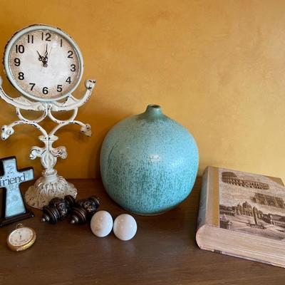 Clock, teal vase, storage book
