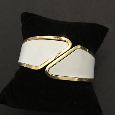 Very nice gold toned, white hinged bracelet