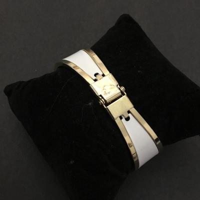 Very nice gold toned, white hinged bracelet