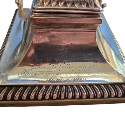 Sale Photo Thumbnail #108: Sheffiled sterling inkwell with double quill holders and hinged lid and glass well insert. Hallmarks. 1918.
Inscription read "To Mr John Braintree Harvey frm his colleagues at Barclay's Bank Colchester March 1919".
A lovely example. 
5 x 5 x 4.5"