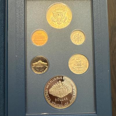 Sale Photo Thumbnail #35: Includes box, book, COA, 6 coins encased. 
Lincoln cent 
Jefferson nickel 
Roosevelt dime
Washington quarter 
Kennedy half dollar 
Constitution Proof (90% Silver - 26.730 grams)