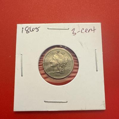 Sale Photo Thumbnail #61: Uncertified, ungraded 
Year:1865
Mint: Philadelphia, no mark 
Denomination: 3 cents
Composition: 75% Copper, 25% Nickel
Approx. Weight: 2 g 
Approx.  Diameter: 18mm 
Edge: Plain 
In great legible condition 
wear consistent with time