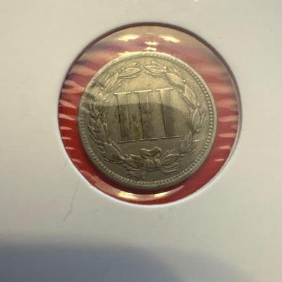 Sale Photo Thumbnail #62: Uncertified, ungraded 
Year:1865
Mint: Philadelphia, no mark 
Denomination: 3 cents
Composition: 75% Copper, 25% Nickel
Approx. Weight: 2 g 
Approx.  Diameter: 18mm 
Edge: Plain 
In great legible condition 
wear consistent with time