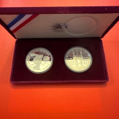 Sale Photo Thumbnail #112: Proof coins 
Each made of 90% Silver and minted in San Francisco. 

1983 discusses thrower with bust of American eagle on reverse. 

1984 Gateway to Olympic Colosseum with American eagle on reverse. 

Each coin is 1.50inches in diameter weighing .86 Troy 
