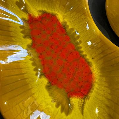 Sale Photo Thumbnail #650: The image shows a vintage California Pottery Lazy Susan serving set, characterized by its vibrant orange, yellow, and red drip glaze and leaf-shaped ceramic dishes. 
Here's more information about this type of piece:
Mid-Century Modern (MCM) Style: This se