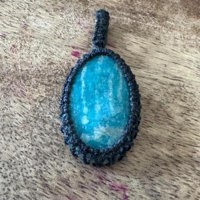 Sale Photo Thumbnail #359: set within a woven macrame design, creating a distinctive and often bohemian-style accessory. 
About Chrysocolla:
Appearance: Chrysocolla is known for its striking blue, blue-green, and sometimes green hues, often displaying a mix of colors and patterns w