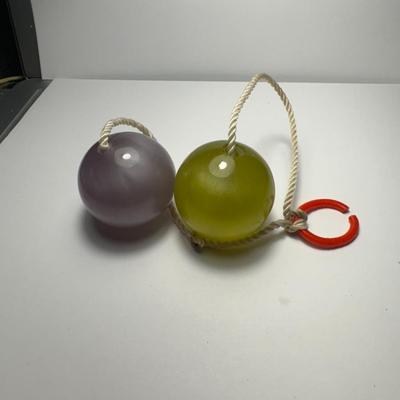 Sale Photo Thumbnail #90: vintage Clackers, also known as Clacker Balls, a popular toy from the late 1960s and early 1970s. They consist of two hard spheres (originally glass, later plastic) on a string attached to a handle or finger tab. The goal is to swing them up and down, mak