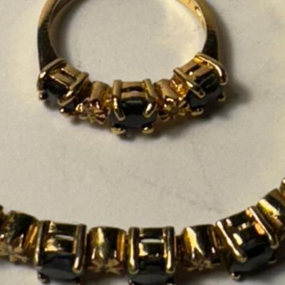 Sale Photo Thumbnail #401: Bracelet and a matching ring, both adorned with what appear to be dark, possibly black or deep blue, gemstones. These are gold over .925 silver pieces, possibly featuring sapphires or black spinel gemstones.