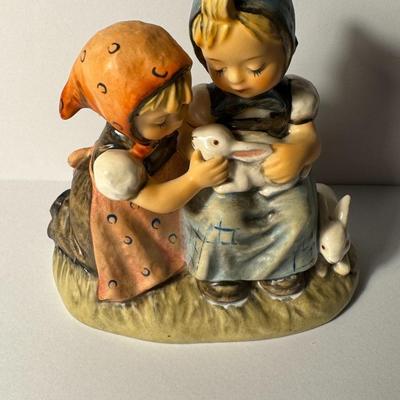 Sale Photo Thumbnail #305: Hummel figurine titled "Easter Time". It features two girls with two bunnies. The figurine is also known by the model number #384