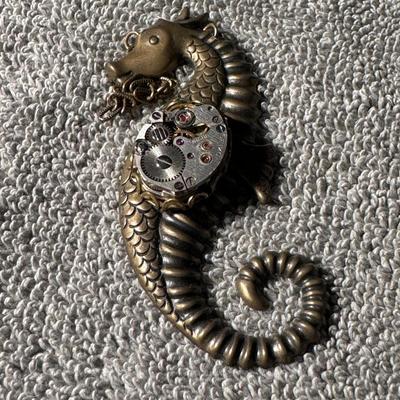 Sale Photo Thumbnail #424: Steampunk Sea Dragon or Seahorse pendant  a distinctive piece of jewelry that blends Victorian-era aesthetics with industrial and mechanical elements. 
Here's a breakdown of its features and context:
Design: The pendant  features a creature resembling a s