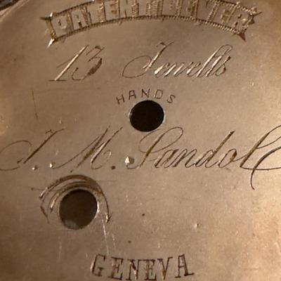 Sale Photo Thumbnail #535: CASE ONLY

I. M. Gandolf: This is likely the watchmaker's or retailer's name.
GENEVA: This indicates the watch was either manufactured in Geneva, Switzerland, or was designed to resemble a high-quality Swiss watch