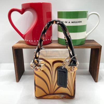 LOT 178: Lenox Kate Spade One In A Million Mug, Art Glass Animal Print Handbag Vase, Leather Coach Hang Tag and Krispy Kreme Mug