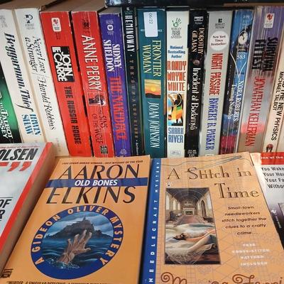 Two shelves of paperback books - Aaron Elkins - Elizabeth Lowell - James Herriot - Great for winter reading!