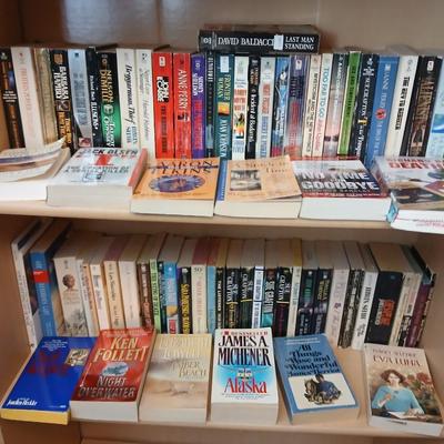 Two shelves of paperback books - Aaron Elkins - Elizabeth Lowell - James Herriot - Great for winter reading!