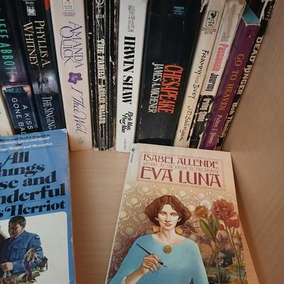 Two shelves of paperback books - Aaron Elkins - Elizabeth Lowell - James Herriot - Great for winter reading!