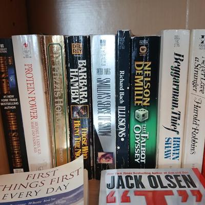 Two shelves of paperback books - Aaron Elkins - Elizabeth Lowell - James Herriot - Great for winter reading!