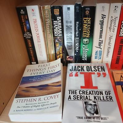 Two shelves of paperback books - Aaron Elkins - Elizabeth Lowell - James Herriot - Great for winter reading!