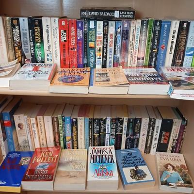 Two shelves of paperback books - Aaron Elkins - Elizabeth Lowell - James Herriot - Great for winter reading!