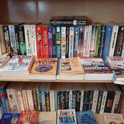 Two shelves of paperback books - Aaron Elkins - Elizabeth Lowell - James Herriot - Great for winter reading!