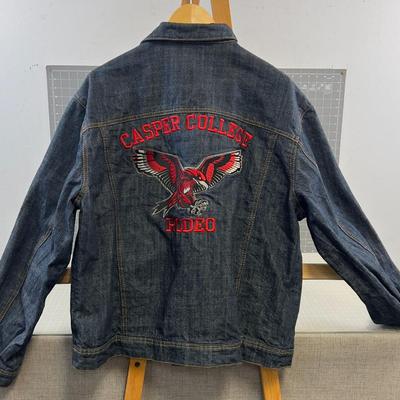 Sale Photo Thumbnail #621: This stylish denim jacket features Casper College Rodeo embroidery and a durable design, ideal for casual or western wear.

• Button-Up Front Closure
• Dual Chest Pockets With Button Flap
• Side Welt Pockets
• Embroidered Casper College Rodeo Logo
