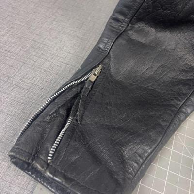 Sale Photo Thumbnail #629: This Wilsons leather motorcycle jacket offers a classic biker look with its durable leather fabric and Thinsulate insulation. Its cropped design and multiple zippered pockets add style and functionality, making it suitable for cool weather rides.

• Zip